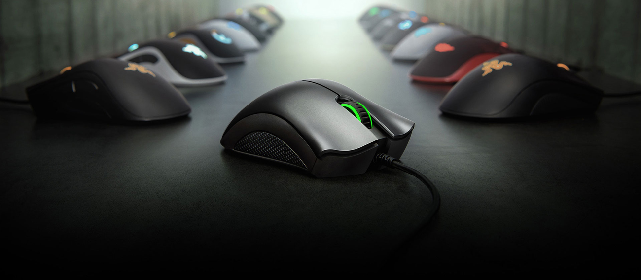 Razer DeathAdder Essential Gaming Mouse is in front of two lines of mice emitting light of different colors.